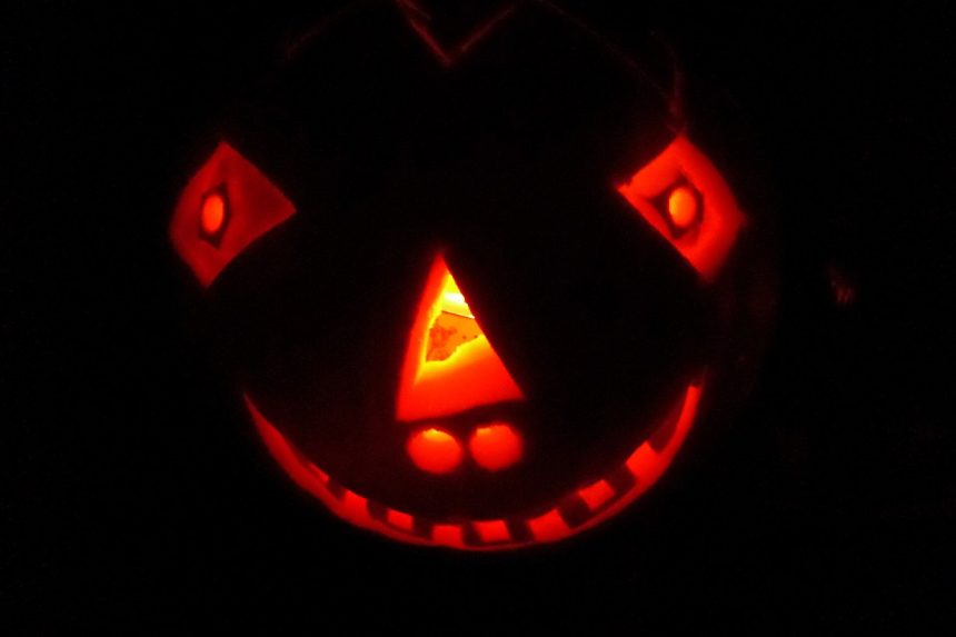 Wydrążona dynia z wyciętą twarzą jako lampion na Halloween