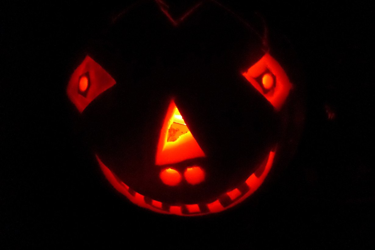 Wydrążona dynia z wyciętą twarzą jako lampion na Halloween