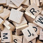 Drewniane płytki z literami do gry w Scrabble rozsypane na stole
