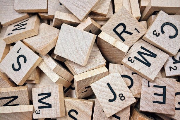 Drewniane płytki z literami do gry w Scrabble rozsypane na stole